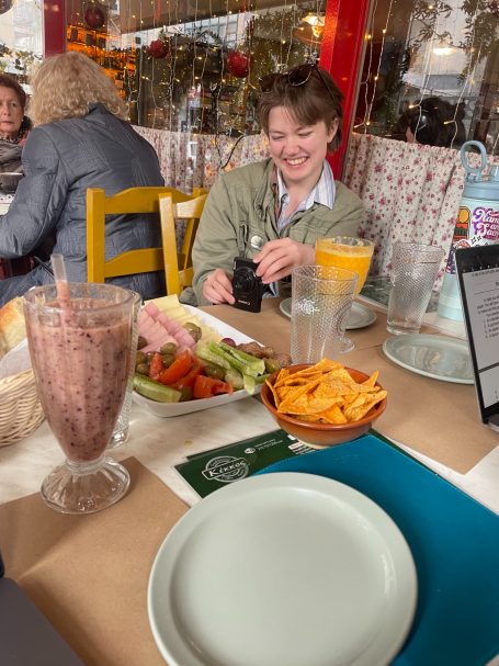 a PLU student taking a photo of the food on the table: a veggie tray, a smoothie, and some sort of crisps?