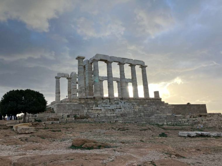the ruins of the temple of poseidon, with ominous clouds above